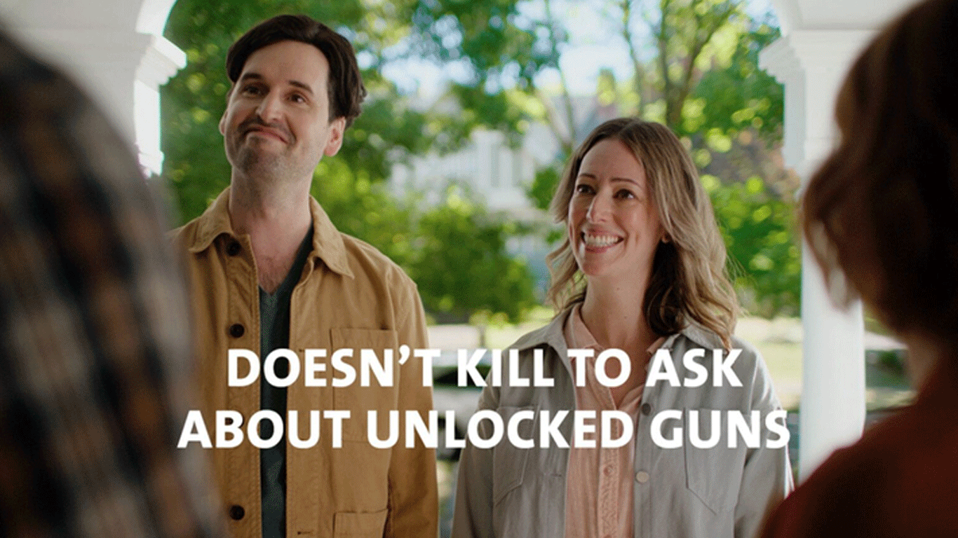 Screen grab of uneasy man and woman speaking to a couple. Text reads “Doesn’t kill to ask about unlocked guns.”