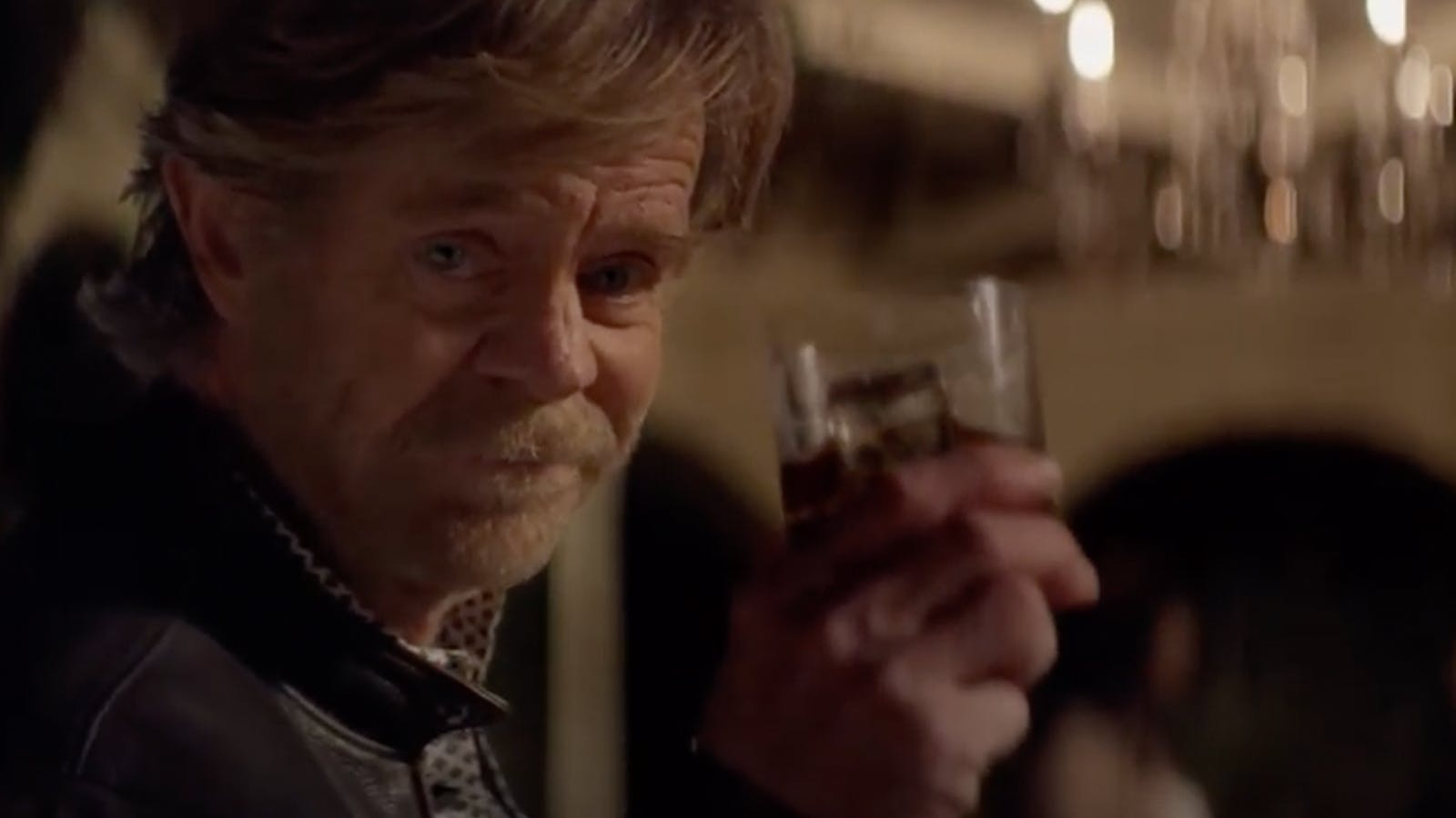 Actor William H. Macy looks at the camera and raises a glass of bourbon for the Woody Creek campaign.